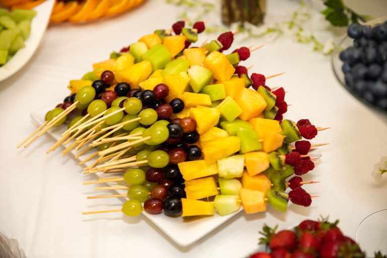 Vibrant fruit skewers including grapes, melons, and berries, perfect for a summer event.